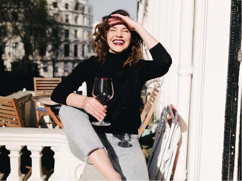 Woman with glass of red wine in the sun