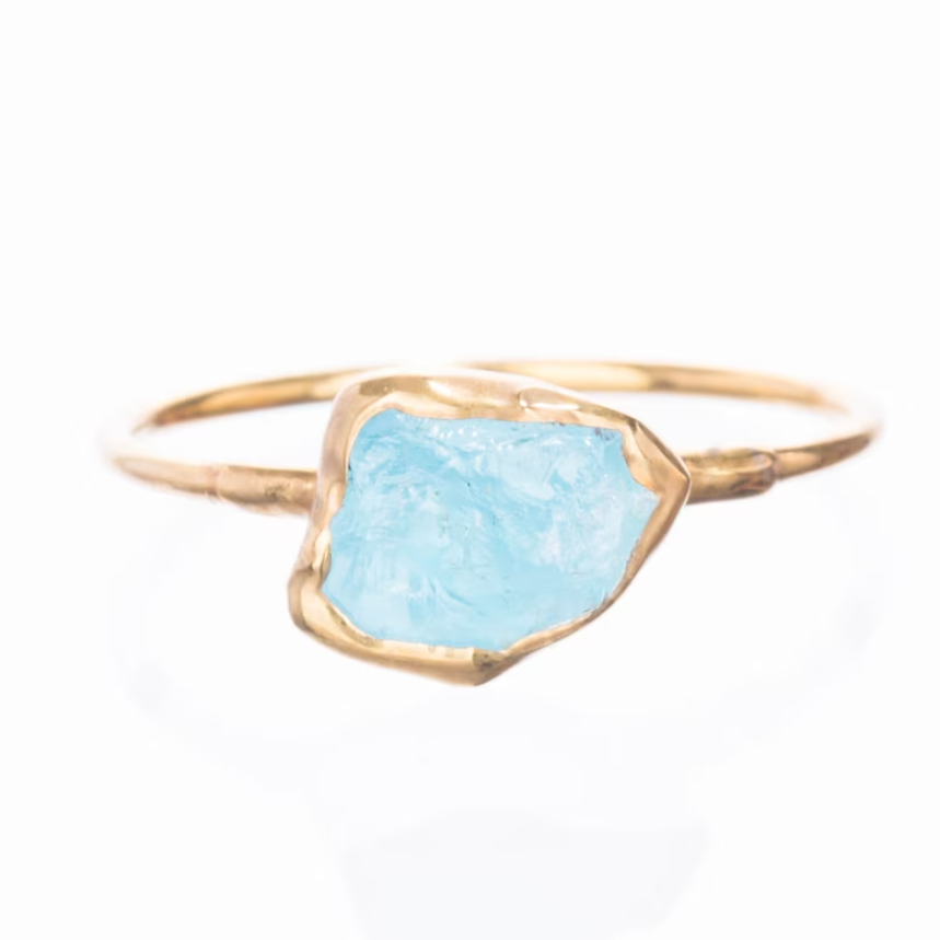 Raw aquamarine stone set in a gold ring