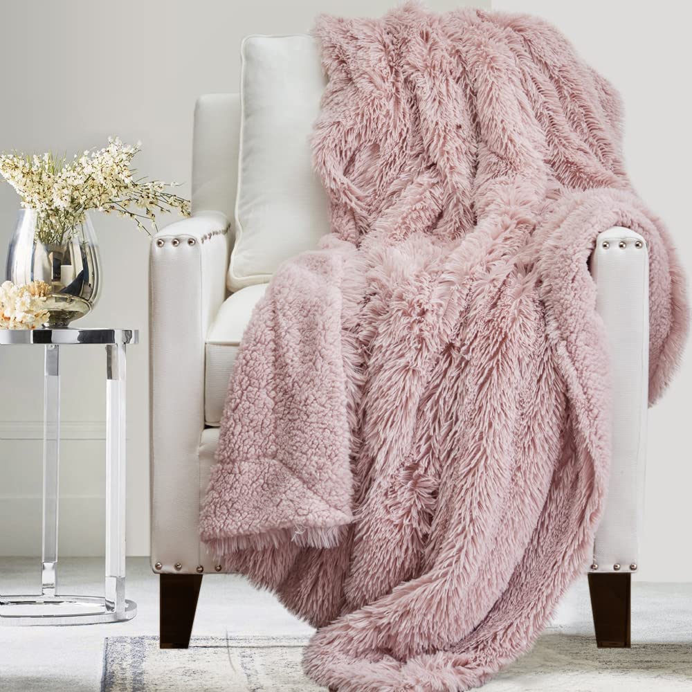 Shag throw blanket in dusty rose color hanging over leather chair