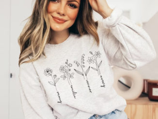 Smiling woman wearing sweatshirt with birth month flowers and names of children for Mother's Day gift